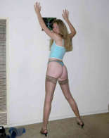 Ein Girl trägt halterlose Nylonstrümpfe und einen String-Tanga