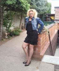 Eine Blondine posiert draussen im kurzen Rock